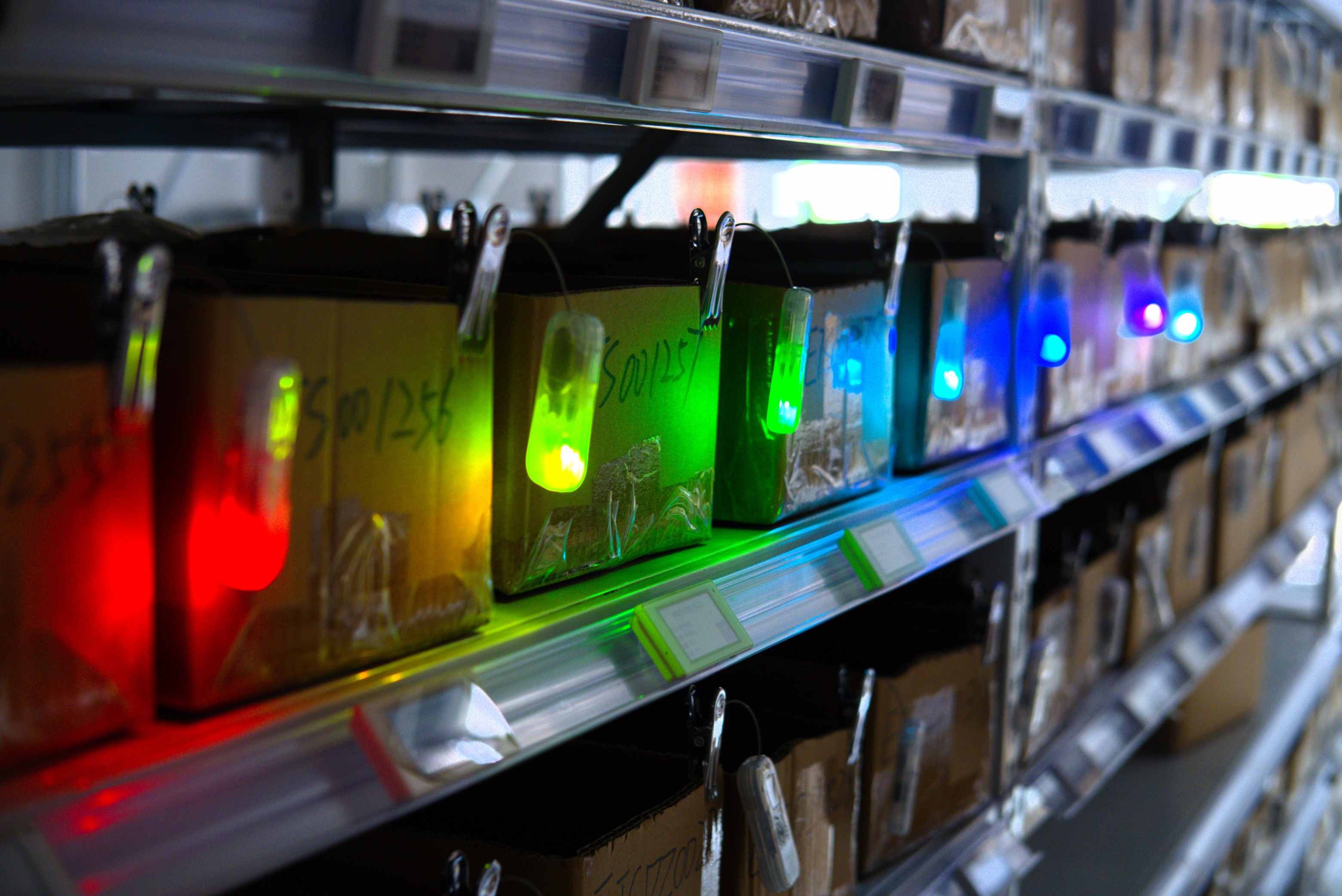 7-Color LED Strategy: Enabling High-Density Multi-User Warehouse Picking. Multiple warehouse pickers in one aisle following different colored LED tags for efficient multi-user warehouse picking.